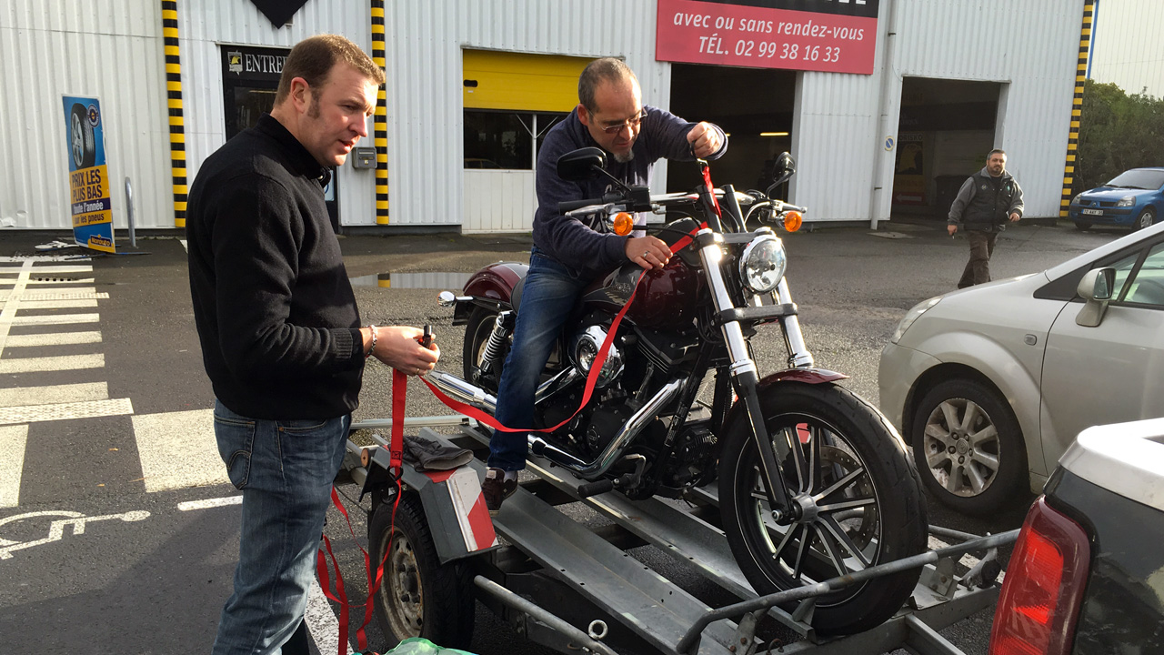 Moto sanglée sur la remorque