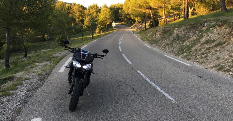 Moto roadster dans un virage sur route ouverte, trajectoire de sécurité
