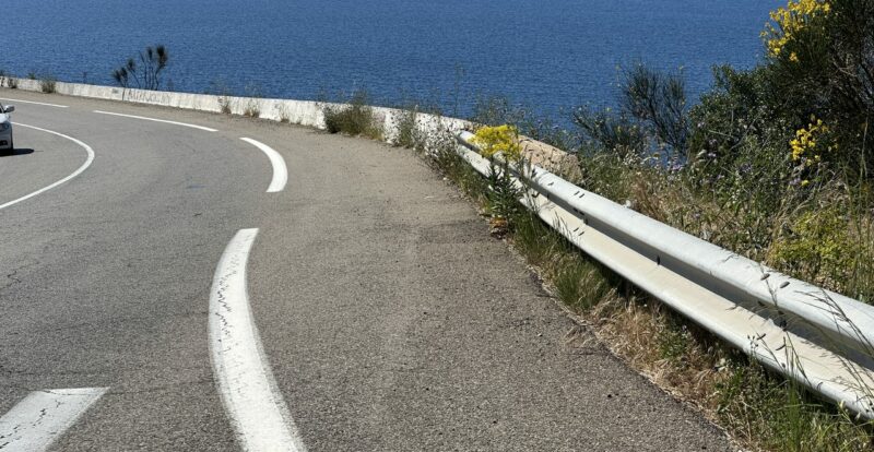 Virage de route côtière avec glissière de sécurité au-dessus de la mer corse