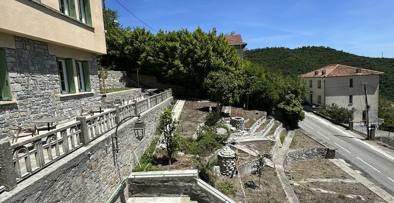 Terrasse en terrasses sur un flanc de colline corse avec escalier et route en contrebas