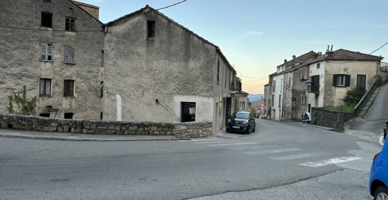 Carrefour désert d'un village corse en pierre au crépuscule, ciel rosé