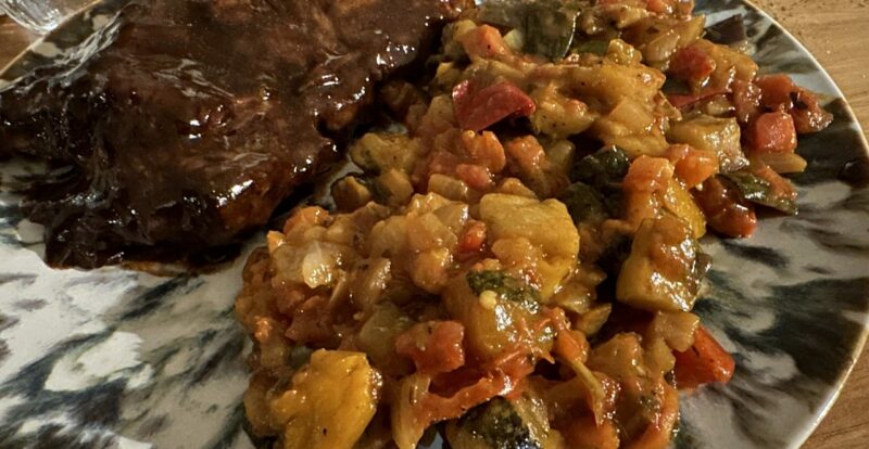 Assiette de viande en sauce et ratatouille de légumes mijotés à la corse