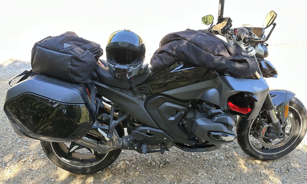 Roadster BMW noir chargé de sacoches, casque et blouson prêt pour le départ