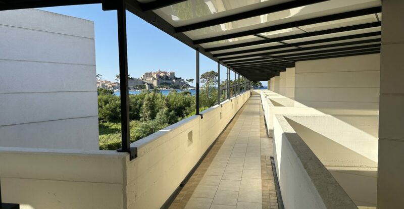 Terrasse couverte d'hôtel avec vue sur la citadelle de Calvi et la mer