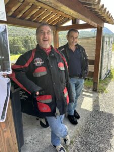 Deux motards souriants sous un abri