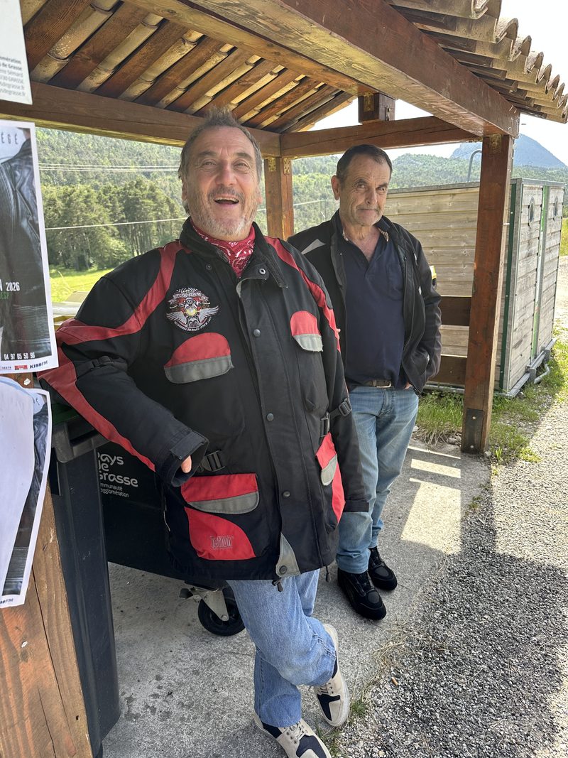 Deux motards souriants sous un abri