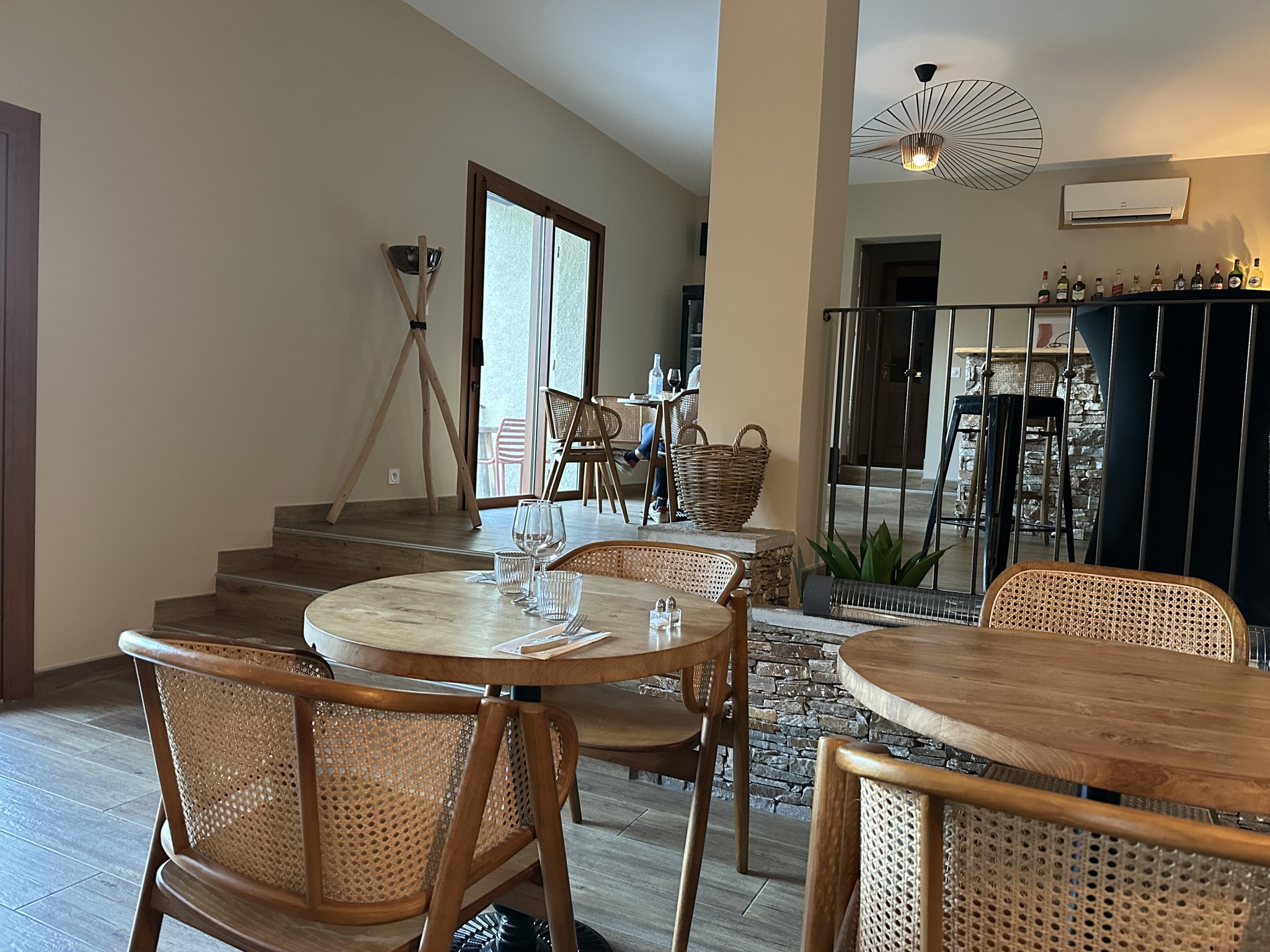 La salle de Chez Coco, calme, feutrée et très cosy, tables en bois et chaises en rotin.