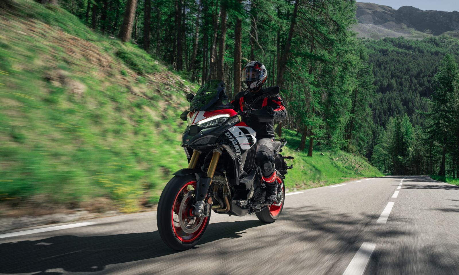 Ducati Multistrada V4 Pikes Peak 2027 livrée course en virage sur route de montagne